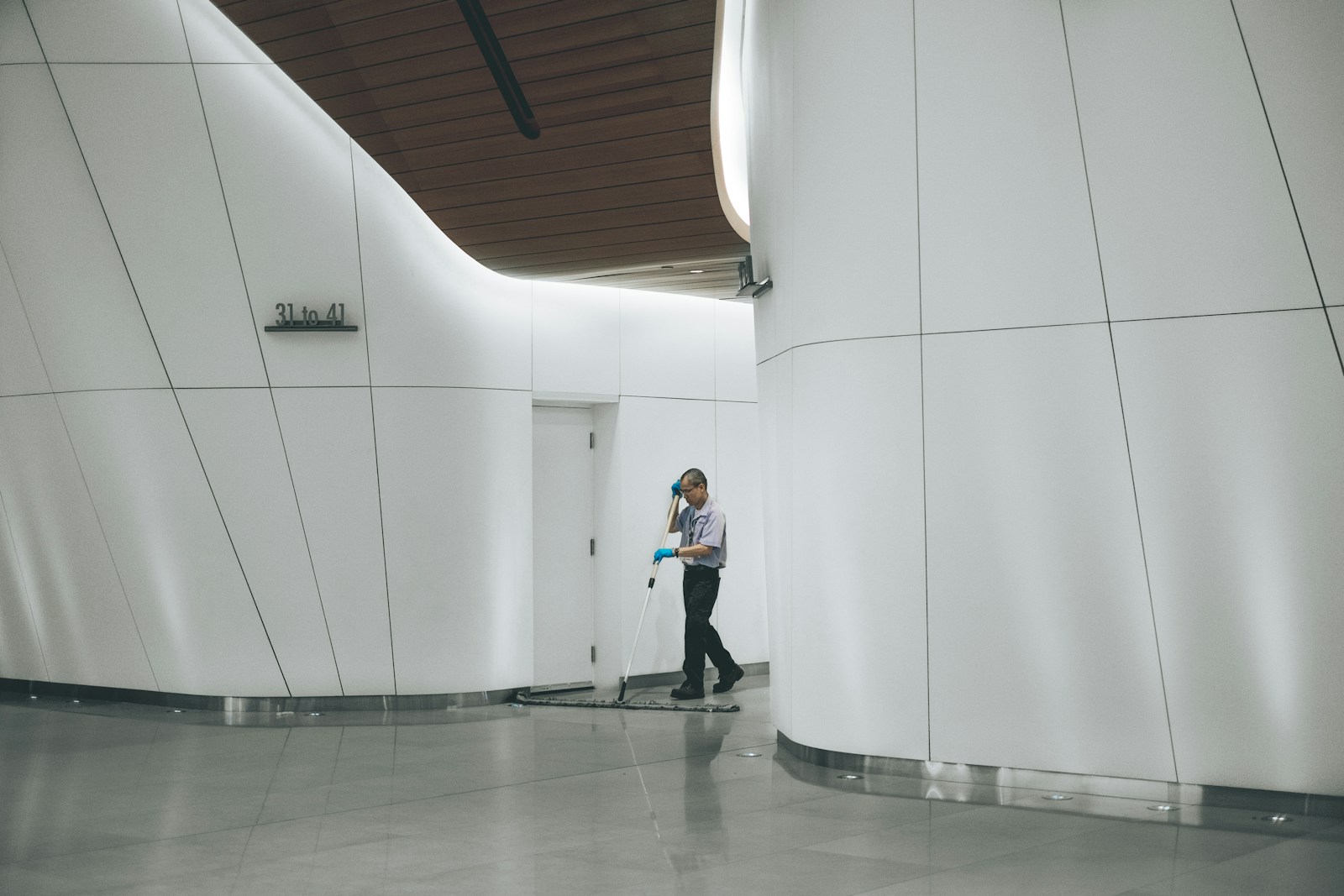 Janitorial worker moving down a corridor with cleaning equipment